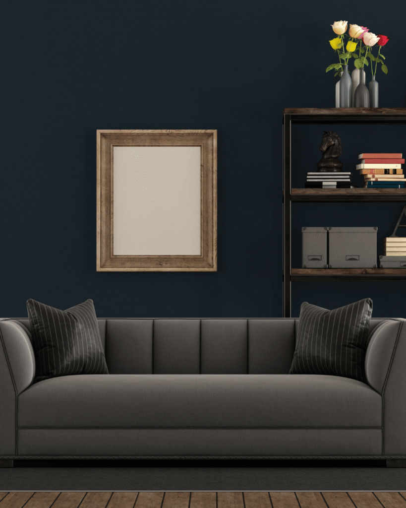 Soggiorno elegante e luminoso con divano grigio scuro, arredi moderni e dettagli raffinati in stile contemporaneo.