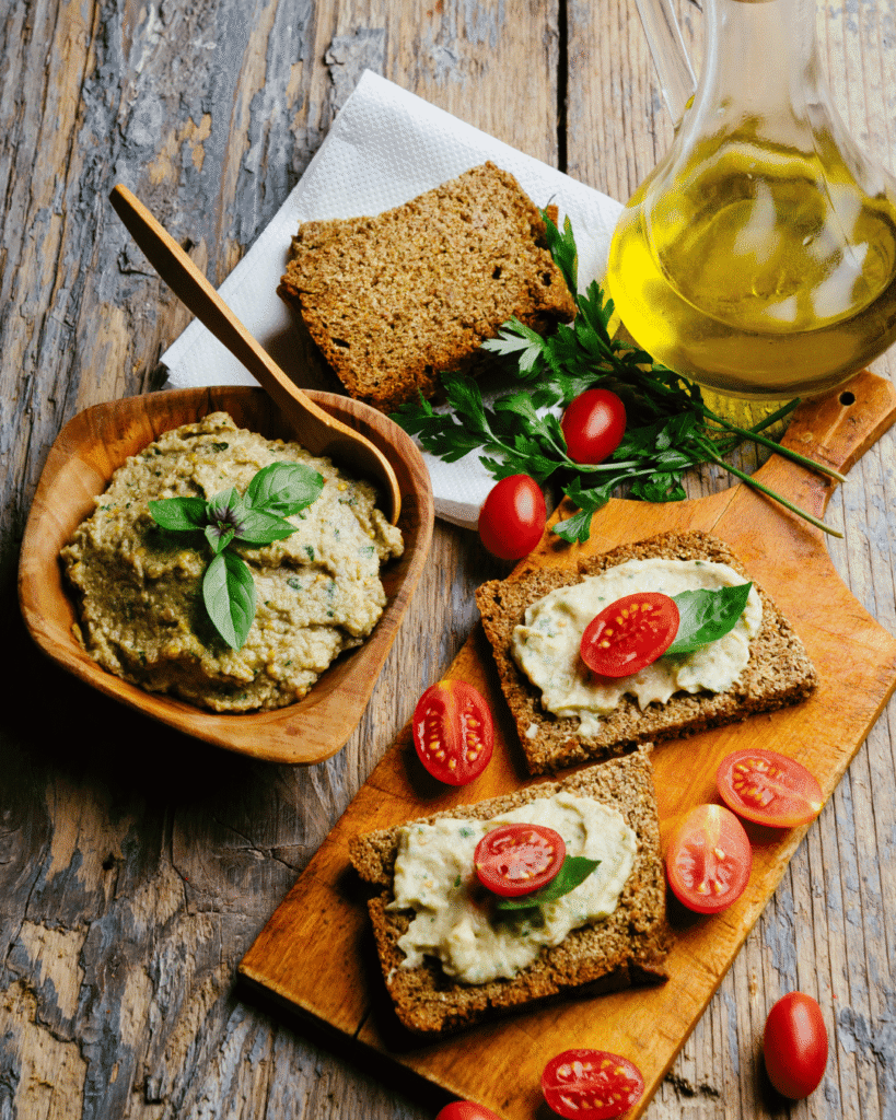 Immagine che rappresenta i principali alimenti della dieta mediterranea: olio extravergine di oliva, pesce azzurro, cereali integrali, legumi, frutta, verdura fresca e frutta secca. Questo modello alimentare, ricco di fibre, grassi sani e antiossidanti, è associato a una migliore salute cardiovascolare, alla prevenzione delle malattie croniche e a una maggiore longevità, soprattutto dopo i 55 anni.