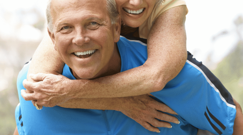 Coppia over 55 sorridente mentre cammina all’aperto, stile di vita attivo e cuore sano