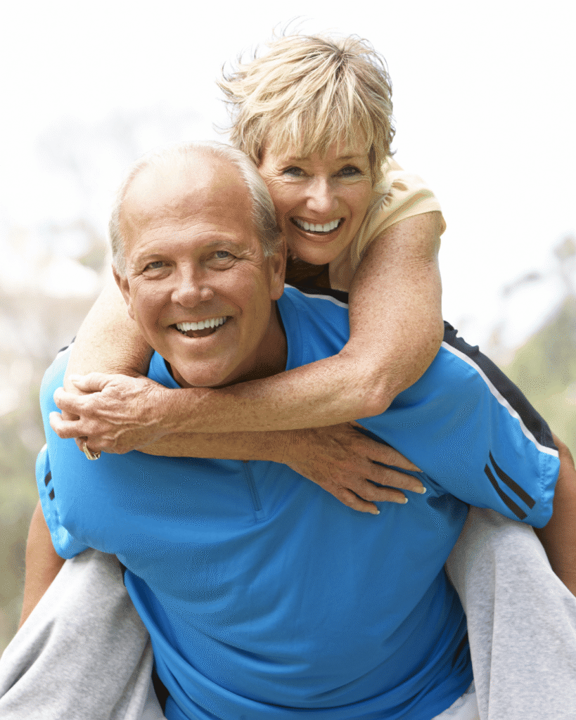 Coppia over 55 sorridente mentre cammina all’aperto, stile di vita attivo e cuore sano