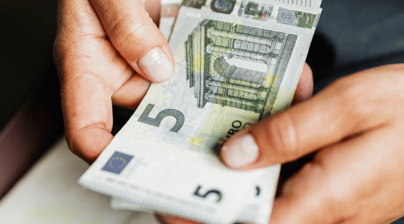 Primo piano di mani femminili che contano banconote da 5 euro, concetto di risparmio e gestione del denaro