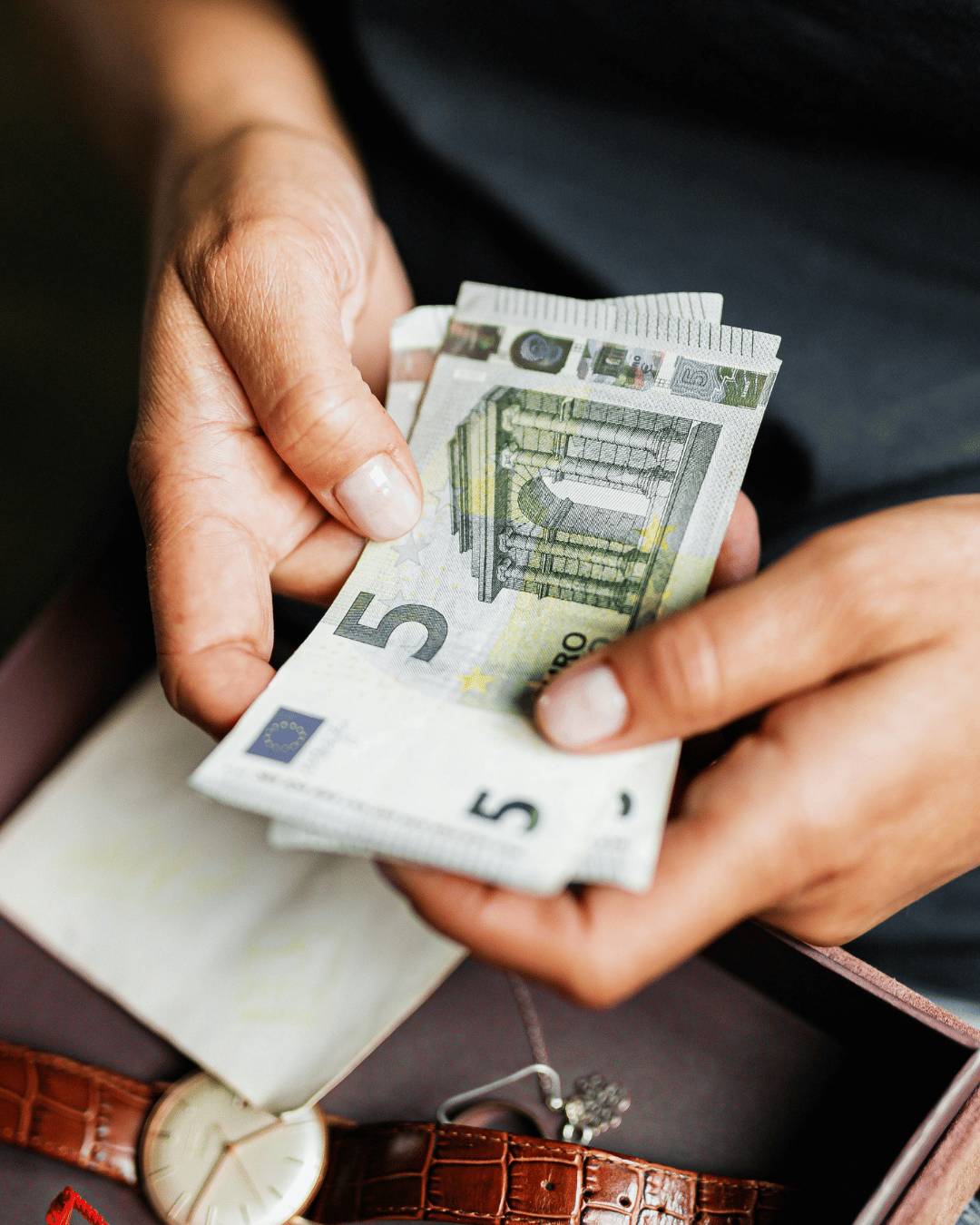 Primo piano di mani femminili che contano banconote da 5 euro, concetto di risparmio e gestione del denaro
