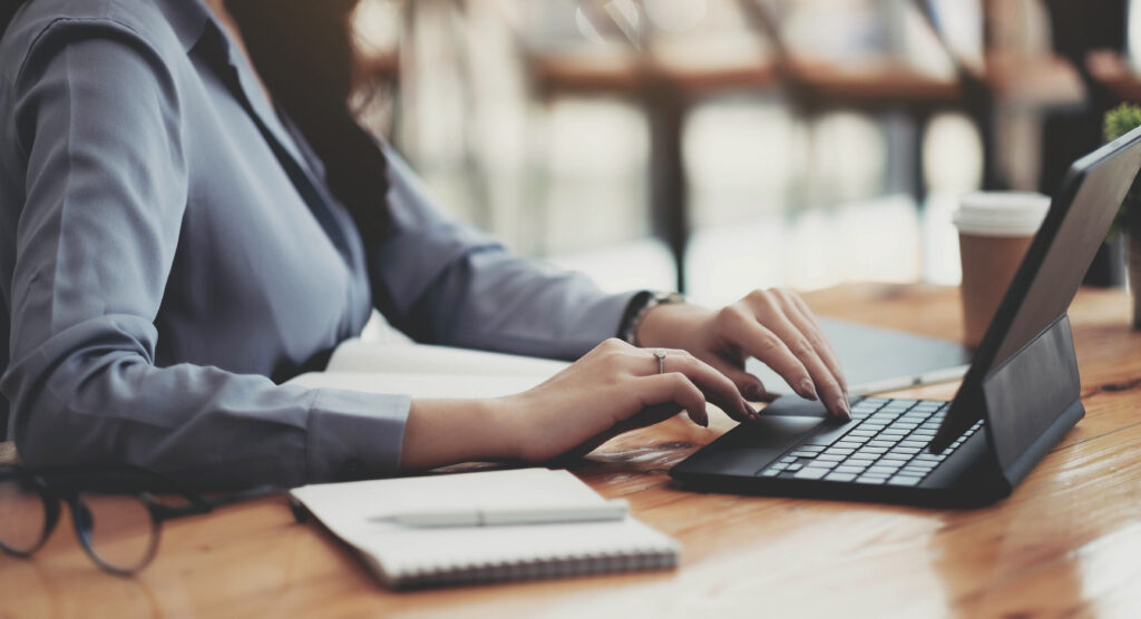 Donna over 50 lavora al laptop da casa pianificando una nuova carriera e un cambiamento professionale dopo i 50 anni