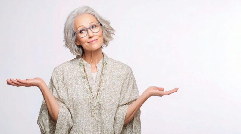 Donna sui 60 anni con occhiali e sciarpa che sorride all’aperto, immagine legata al benessere e all’invecchiamento sano.