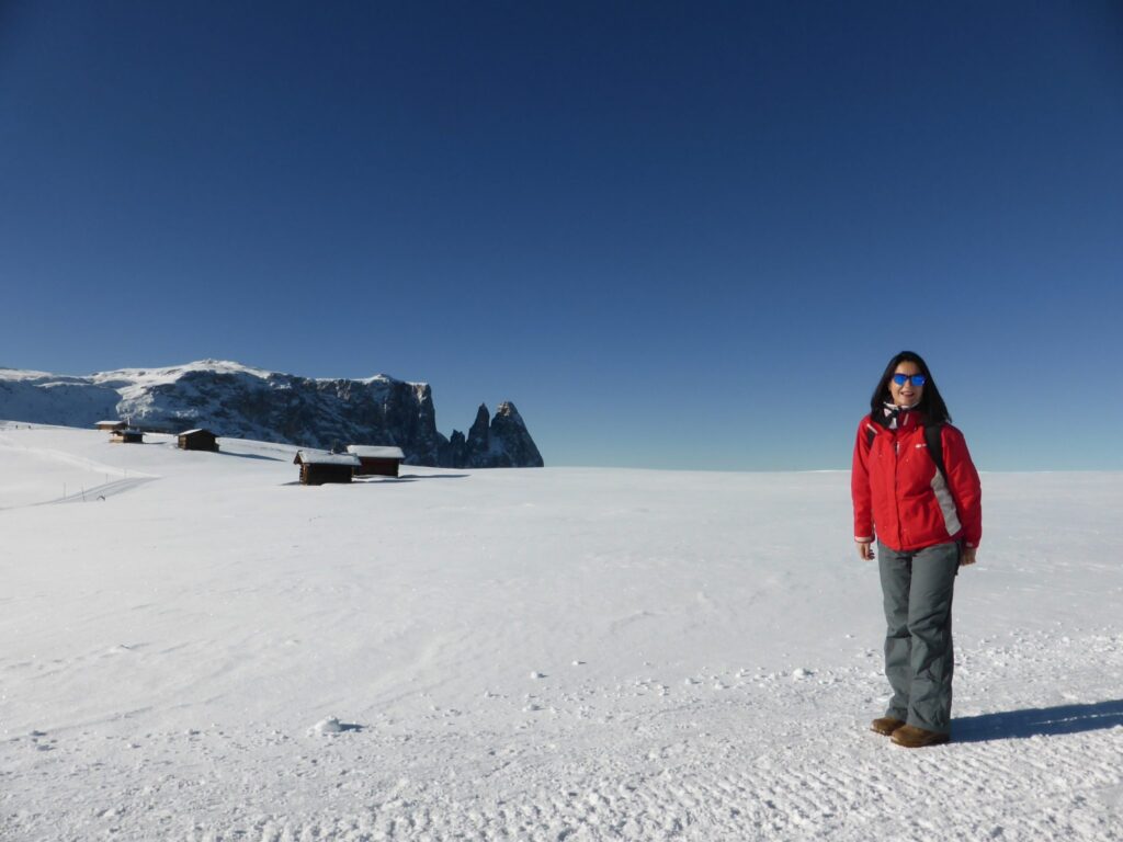Panorama innevato dell’Alpe di Siusi con turisti che passeggiano tra le montagne