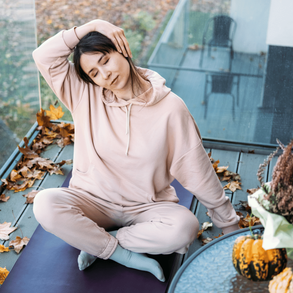 Donna adulta che esegue una posizione yoga all’aperto al tramonto, immersa nella natura, per migliorare equilibrio, flessibilità e benessere psicofisico