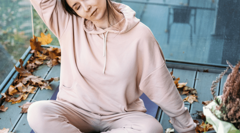 Donna adulta che esegue una posizione yoga all’aperto al tramonto, immersa nella natura, per migliorare equilibrio, flessibilità e benessere psicofisico